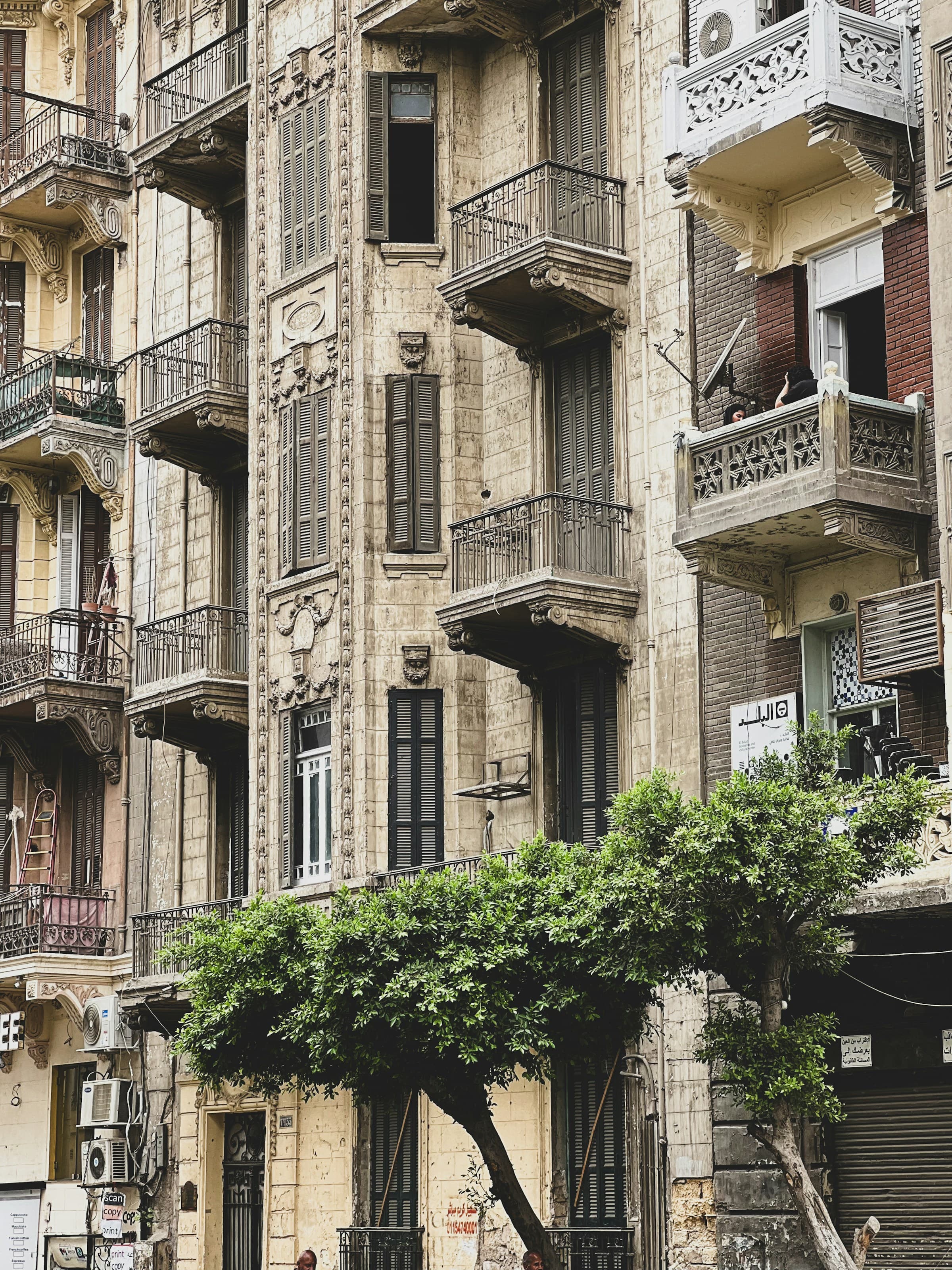 Stone facade detail with balconies and wooden shutters